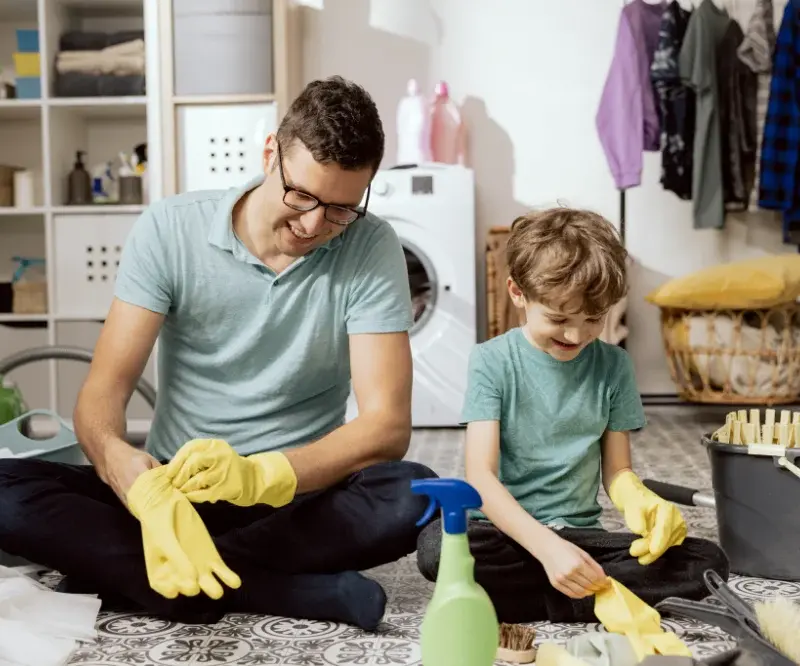 Far og søn har det sjovt med at gøre rent i deres eget hjem